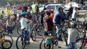 Cyclists of all ages wait in front of Wheels of Justice for the August, 2012 Bike About Town Ride to begin